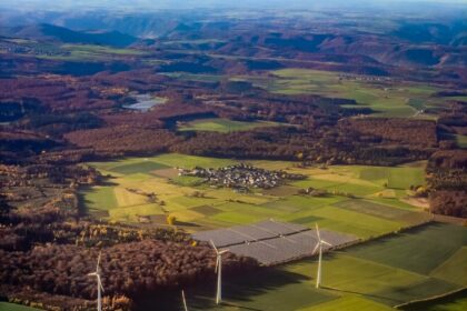 Wind turbines and solar panels in a rural landscape.