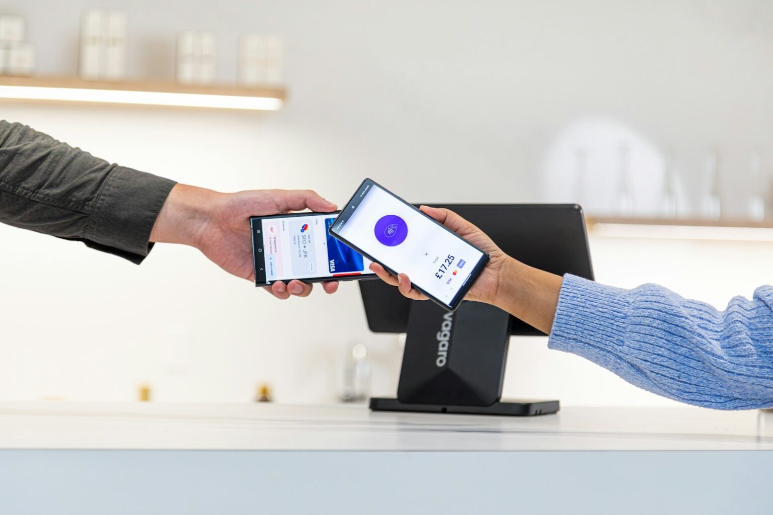 Customer paying with smartphone at point of sale terminal.