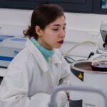 Young woman in lab coat working with equipment