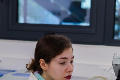 Young woman in lab coat working with equipment