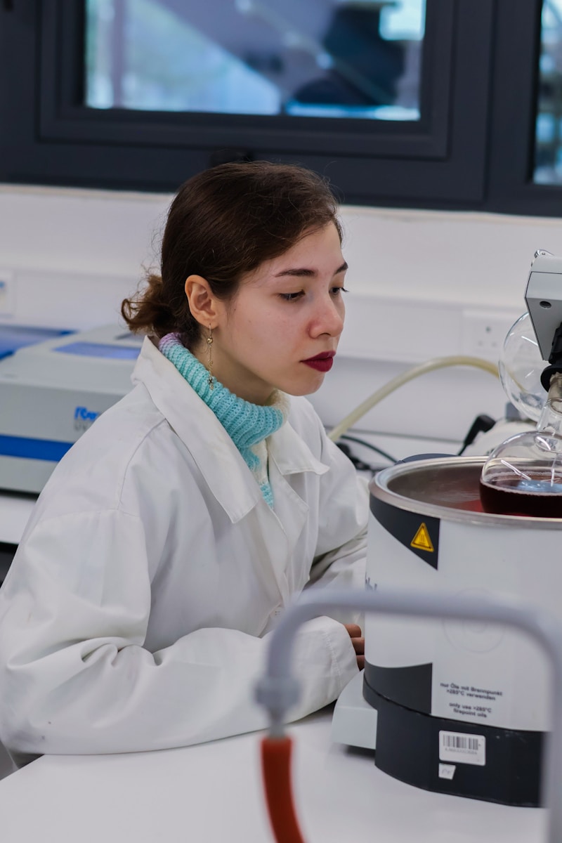 Young woman in lab coat working with equipment