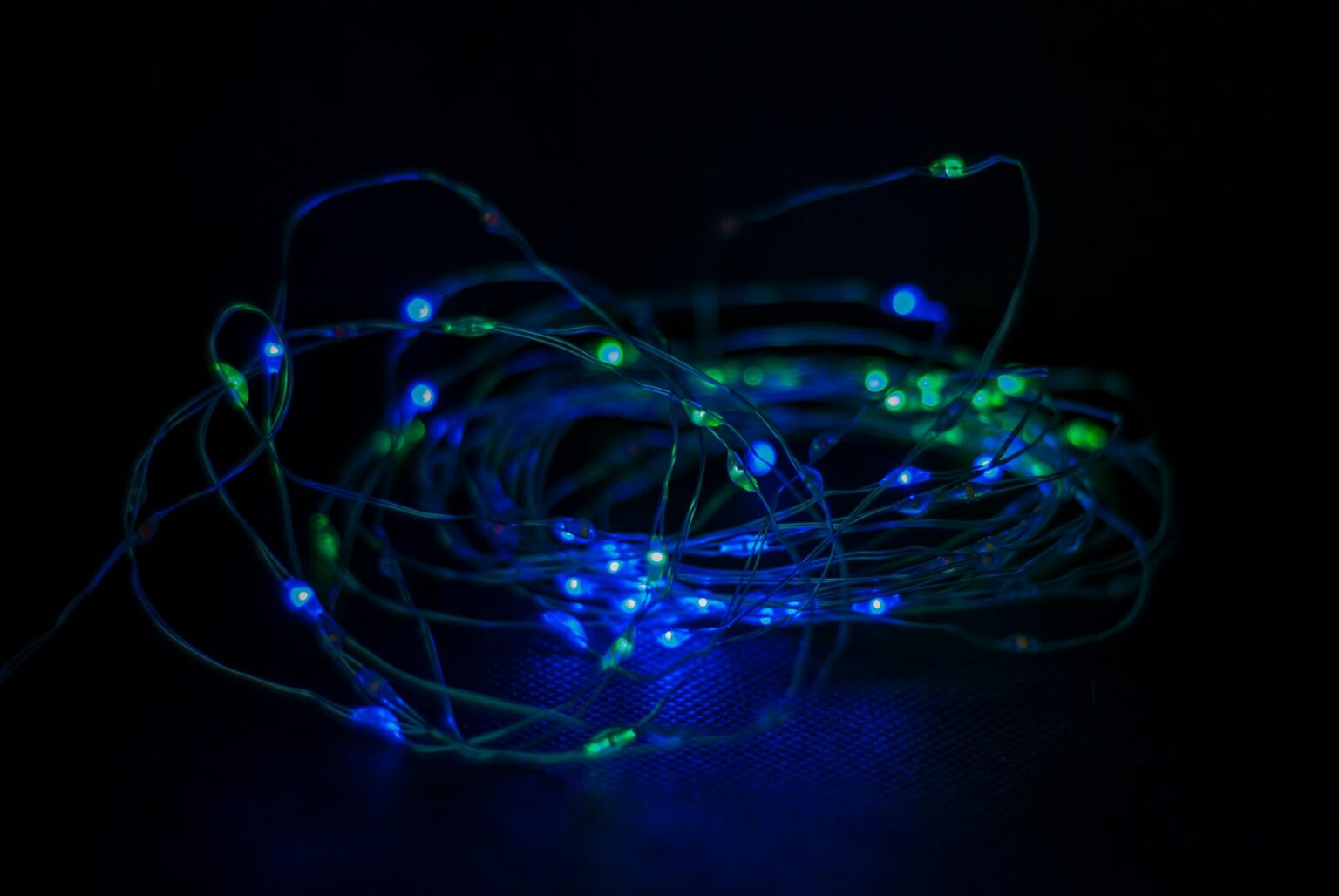 a bunch of blue and green lights in the dark