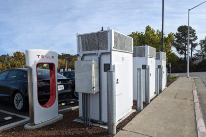 An electric car charging at a Tesla Supercharger station in San Mateo, California