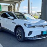 White Volkswagen ID.4 electric SUV plugged in at a covered charging station