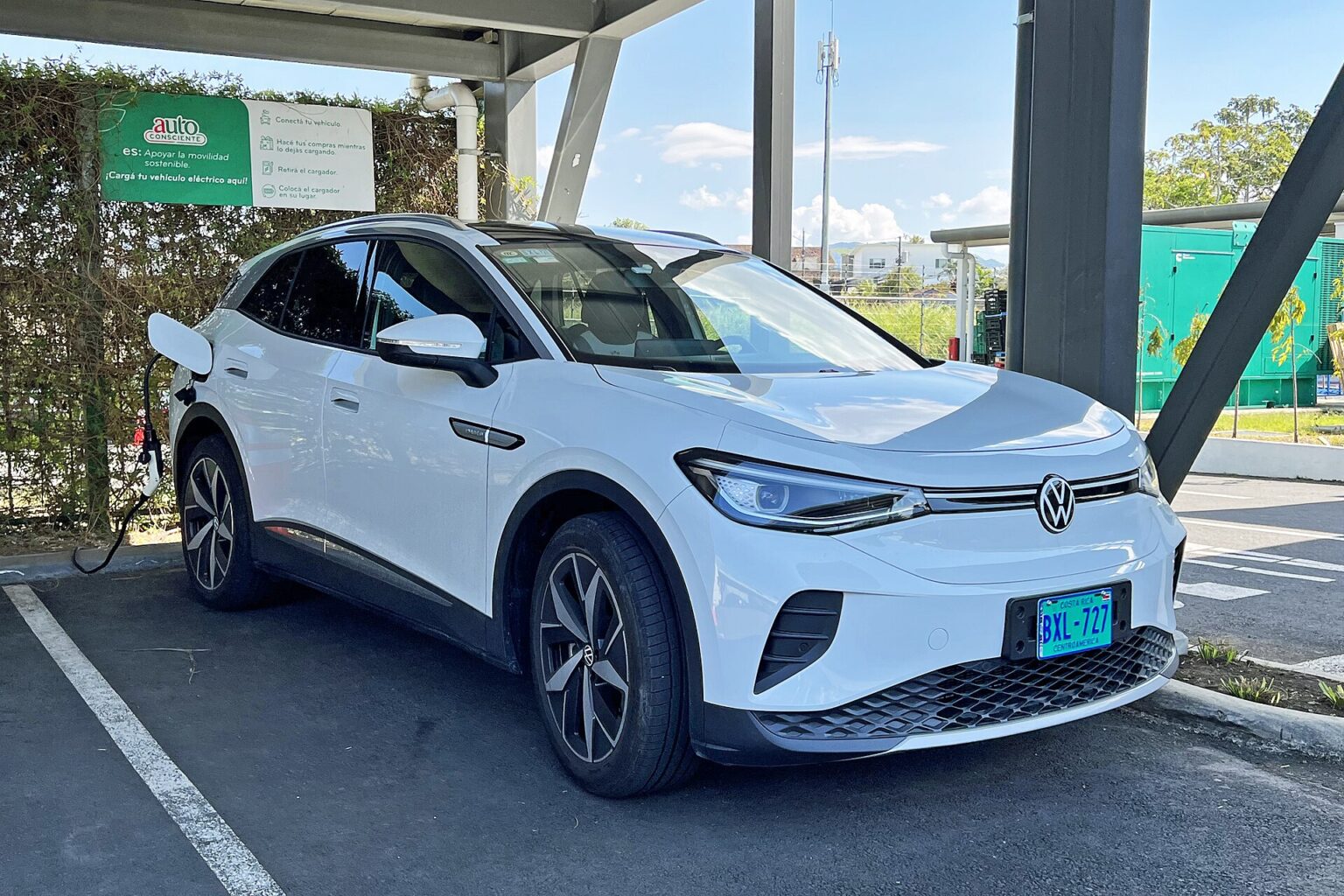 White Volkswagen ID.4 electric SUV plugged in at a covered charging station